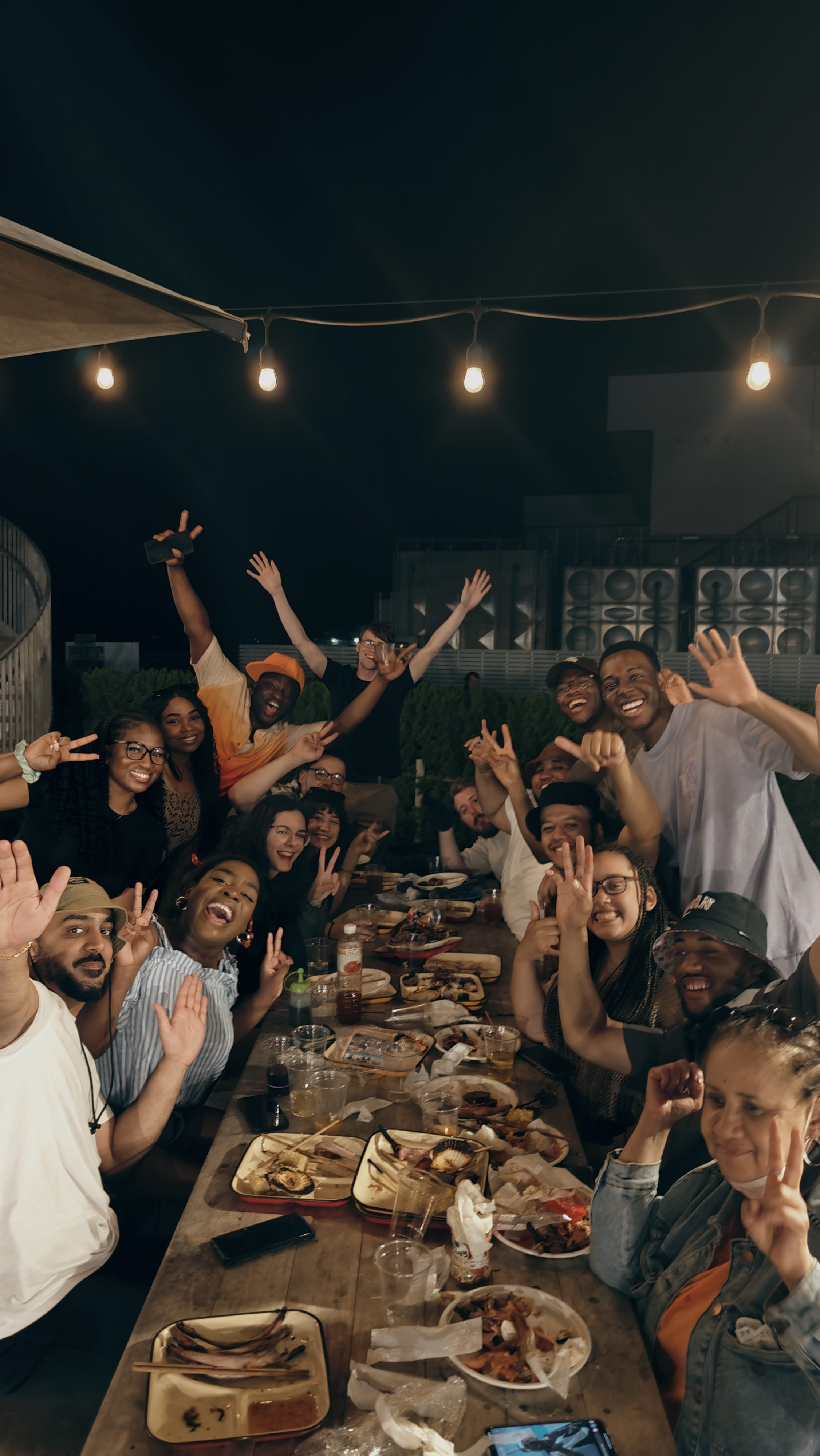 Friends dining together at night under string lights in Japan